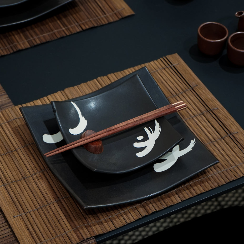Handmade small black motif dinner plate set with a pair of chopsticks.