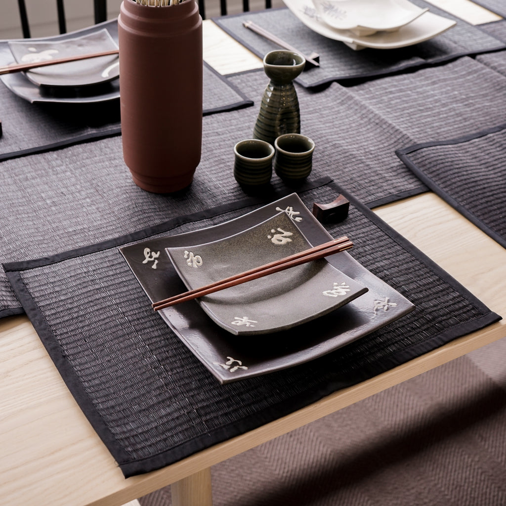 Throwing a modern yet authentic vibe to the dining. These black reed placemats are hand woven in a traditional way at the finest quality. Smooth the edge around with 100% cotton trim. Their soft and strong texture makes them durable as well as attractive. Wiping the mess off with a dry or damp cloth to keep it clean. Rolling or folding it and keep it neatly in the corner of your storage. Complete the dining setting with a matching reed runner. Size W33 x L45 cm
